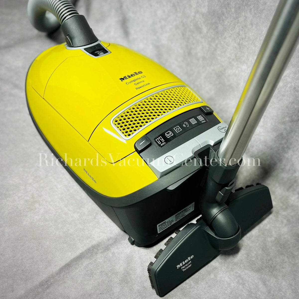Miele canister vacuum with hose, wand, and parquet twister bare floor brush.