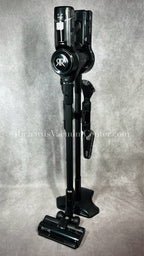Black vacuum cleaner with attachments on a gray background